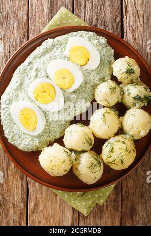 German cuisine boiled potatoes with eggs frankfurt green sauce close-up in a plate. Vertical top view from above Stock Photo