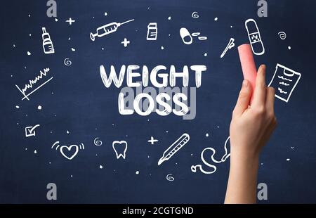 Hand drawing WEIGHT LOSS inscription with white chalk on blackboard, medical concept Stock Photo