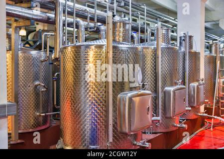 Stainless steel reservoirs for wine at modern winery indoor. Stock Photo