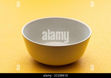Empty white Cup on a yellow background, isolate. Stock Photo