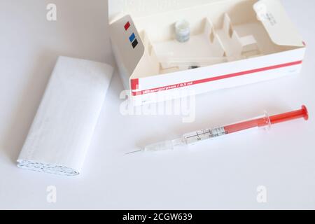 Used dose of Interferon injectable solution in pre-filled syringe for the treatment of Hepatitis C, next to the medicine's leaflet and carton box Stock Photo