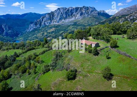 Tejo - European yew (Taxus baccata) and Chapel of Santa María in Bermiego in the Quirós council, in the Las Ubiñas-La Mesa Natural Park. Asturias. Spa Stock Photo