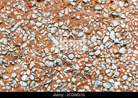 Red wall covered small white rocks. Stock Photo