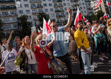 Protesters shouting slogans wave Polish flags during the march.A demonstration of the opponents of restrictions related to the coronavirus pandemic marched through the streets of Warsaw. Participants are against the obligation of wearing protective masks. “No more lies, no more masks, stop the pandemic', participants chanted slogans during the protest. Despite the obligation, protesters did not have face masks and did not keep a safe distance. Stock Photo