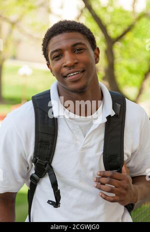 african american man student with backpack in studio smiling at the ...