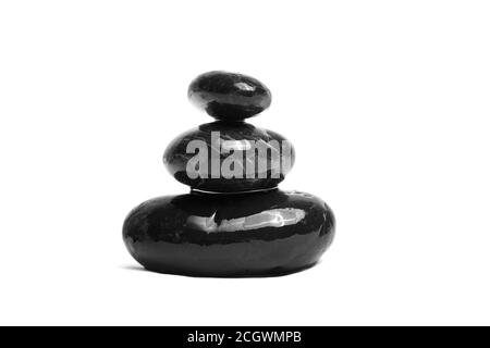 Stacked smooth black stones. Sea pebble. Balancing wet pebbles isolated on white background Stock Photo