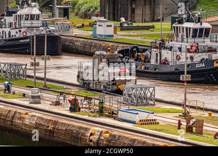 City of Knowledge, Panama - November 30, 2008: Miraflores locks. The Progresso and Guia tugboats on the brown water of the locks. Machines and workers Stock Photo