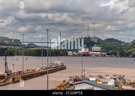 City of Knowledge, Panama - November 30, 2008: Miraflores locks. Brown water lake between different locks with ships. Cloudscape, green mountains and Stock Photo