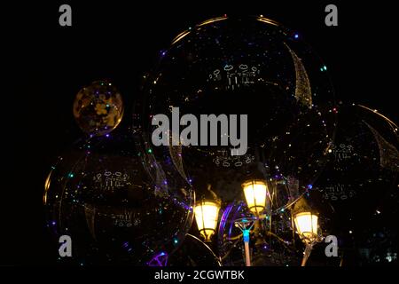 Christmas lights reflected in transparent balloons with a streetlight in the background Stock Photo