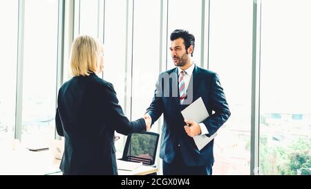 Business people handshake in corporate office showing professional agreement on a financial deal contract. Stock Photo
