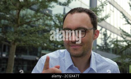 Smiling handsome young man enjoying music looking to camera. Stock Photo