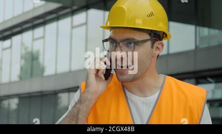 Angry engineer talking on the phone while walking. Stock Photo
