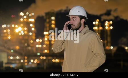 Young male contractor engineer working at factory talking on mob Stock Photo