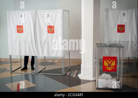 A ballot box with the coat of arms of the Russian Federation with ballots seen at a polling station.In 2020, elections in Russia will be held for three days (from September 11 to 13). A single voting day is on September 13. This year, 17 heads of Federal subjects (governors) and deputies of legislative assemblies of state power in 11 regions of the Russian Federation will be elected in many regions, they will vote for candidates for local authorities, municipalities, for the post of heads of urban economy, mayors of cities and heads of settlements. In the Tambov region, elections of the Govern Stock Photo