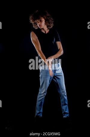 Skinny rock guy wearing  blue jeans pants isolated on black backgorund Stock Photo