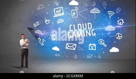 Businessman defending with umbrella from CLOUD GAMING inscription, modern technology concept Stock Photo