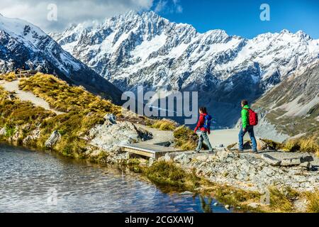Hiking travel nature hikers in New Zealand mountains. Mount Cook landscape. Couple people walking on Sealy Tarns hike trail route towards Mueller Hut Stock Photo