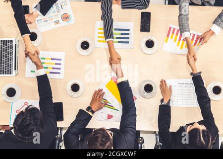 Group business people handshake at meeting table in office together with confident shot from top view . Young businessman and businesswoman workers express agreement of investment deal. Stock Photo