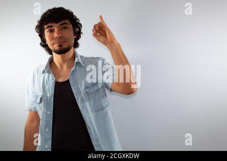 young hispanic deaf man using sign language to communicate, on a white background wearing casual clothes Stock Photo