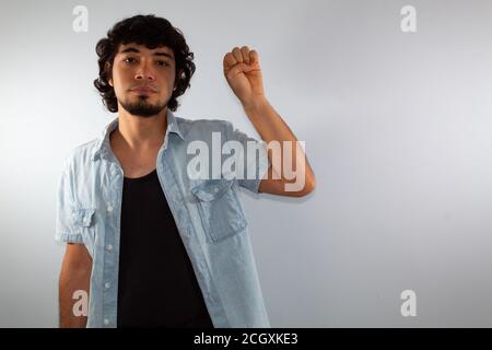 young hispanic deaf man using sign language to communicate, on a white background wearing casual clothes Stock Photo