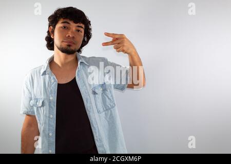 young hispanic deaf man using sign language to communicate, on a white background wearing casual clothes Stock Photo