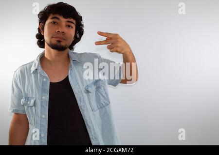 young hispanic deaf man using sign language to communicate, on a white background wearing casual clothes Stock Photo