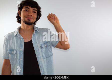 young hispanic deaf man using sign language to communicate, on a white background wearing casual clothes Stock Photo