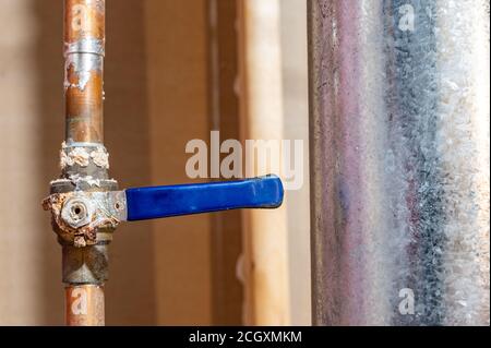 hot water line with a ball valve heavily rusted and damaged Stock Photo