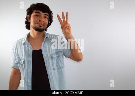 young hispanic deaf man using sign language to communicate, on a white background wearing casual clothes Stock Photo