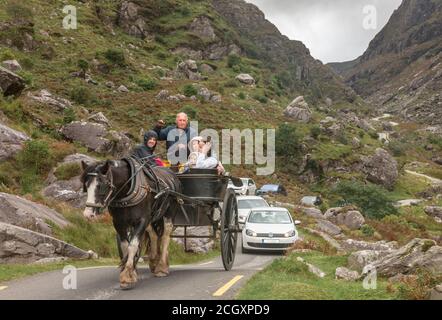 Gap of Dunloe, Killarney, Kerry, Ireland. 12th September, 2020. A family take a leisurely afternoon drive on a jaunting car followed by a stream of traffic through the narrow road at the Gap of Dunloe, Co. Kerry, Ireland.  - Credit; David Creedon / Alamy Live News Stock Photo