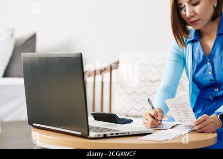 Businesswoman checking bills Stock Photo