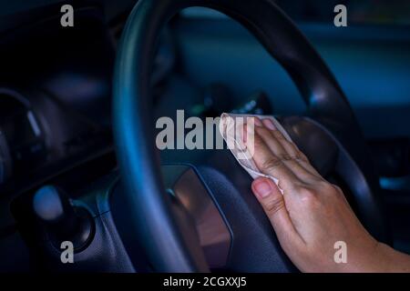 Asian women spry soap and clean car steering wheel with napkin, concept for  Coronavirus, Covit-19 prevention and disinfection. Stock Photo