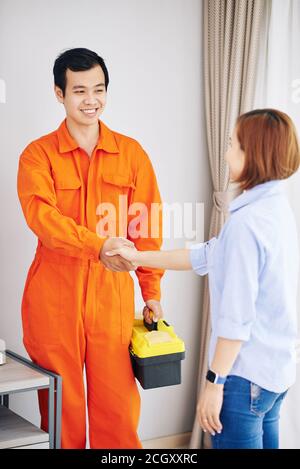 Technician and housewife shacking hands Stock Photo