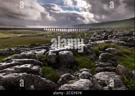 Ribblehead  Viaduct on the Settle-Carlisle railway in the Yorkshire Dales National Park, seen from nearby limestone pavement rocks during a rain storm Stock Photo