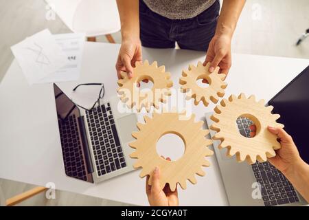 Teamwork, cooperation and successful strategy concept. hands of business people with gears, top view Stock Photo