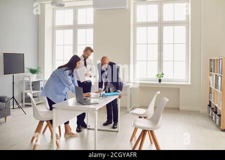 Team of office employees analyzing data reports or dealing with software problems Stock Photo