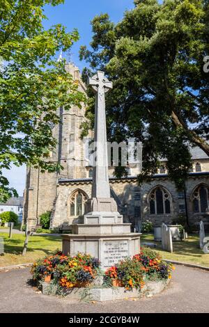Stone war memorial in the churchyard of Sidmouth Parish Church, commemorating local fallen in the Great War, Sidmouth, a Jurassic Coast town in Devon