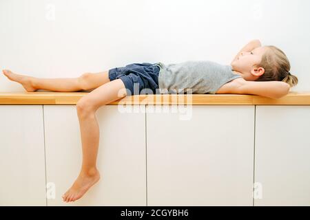 Seven year old boy lying on a corridor shelf, his school closed down