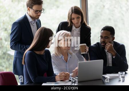 Multiracial colleagues brainstorm on laptop at meeting Stock Photo