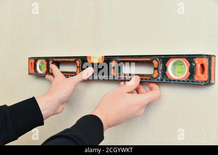 Professional measuring equipment. Worker hold in hand spirit level instrument. Stock Photo