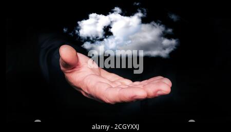 Man hand hold in levitation a clouds on black background. Palm on a black background. Magic Cloud computing concept. Stock Photo