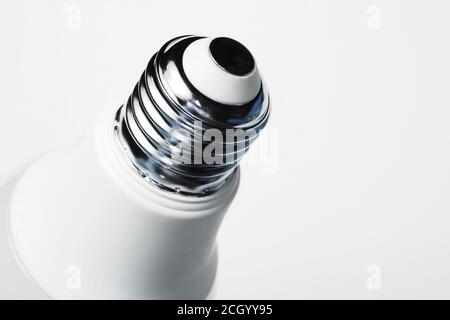 Energy saving led economic lightbulb close up. Metal base with lamp thread on a white background. Stock Photo