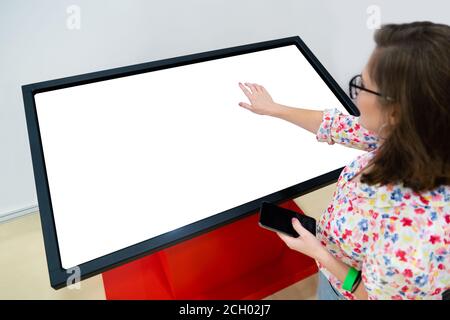 A woman with phone using contactless self service kiosk Stock Photo