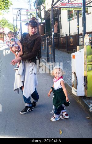 Jewish young woman with two toddlers, boy and girl, walks on Pushkin street in Uman (Ukraine) in the week before the Rosh-ha-Shana in September 2020 Stock Photo