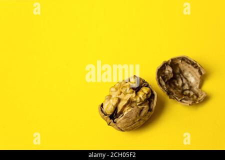 Cracked Walnut On Yellow Background. Close-Up, copy space Stock Photo