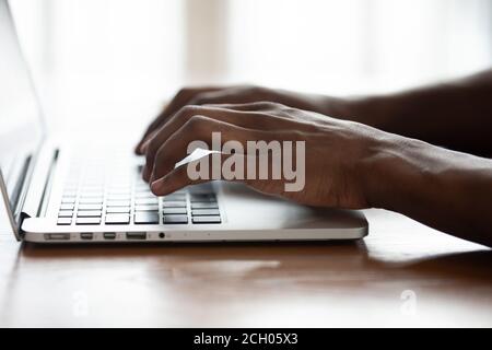 Close up of biracial man working typing on laptop keyboard Stock Photo