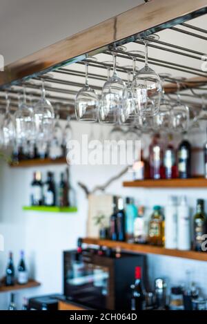 Collection of wine glasses on a bar hanging from the ceiling Stock Photo