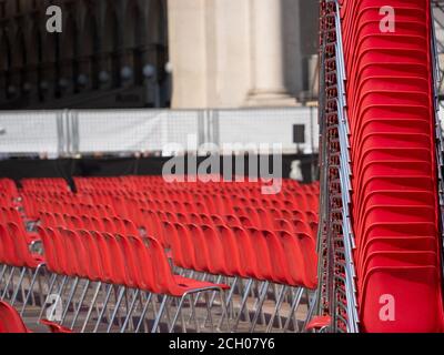 long rows of empty red chairs before an outdoor concert in a large square Stock Photo