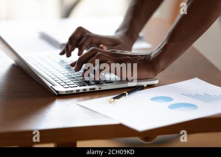 Close up of biracial male employee typing on keyboard Stock Photo
