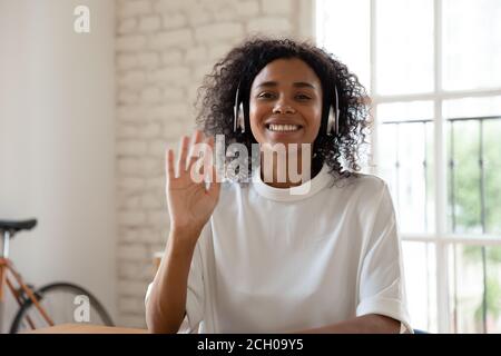 Smiling biracial woman wave having video call in office Stock Photo